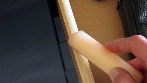 Eine Hand reibt mit Seife über den Schubladenschieber, um eine klemmende Schublade im Möbelstück zu lösen.