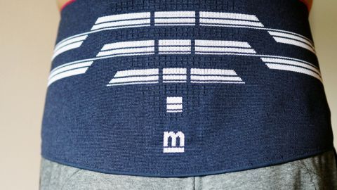 Ein Nierengurt ist um die Taille einer Person angelegt, um bei Kreuzschmerzen Unterstützung zu bieten.