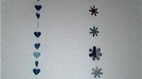 Eine Girlande aus Herzen und Blumen schmückt eine helle Wand und schafft eine festliche, einladende Atmosphäre.