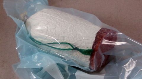 Ein luftdicht verpacktes Stück Wurst liegt auf einem hellen Untergrund, bereit zum Einfrieren, um Haltbarkeit zu verlängern.