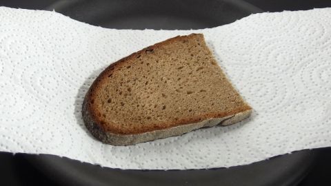 Ein Stück Brot liegt auf einem Küchentuch in einer schwarzen Schüssel, um den Abwasch zu reduzieren und die Hygiene zu fördern.