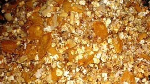 Eine Mischung aus knusprigem Müsli zeigt Haferflocken und Trockenfrüchte in einer Schale, bereit zum Genießen.