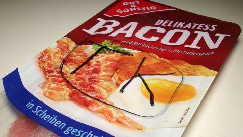 Eine Packung Bacon mit der Aufschrift "GUT & GÜNSTIG DELIKATESS BACON, mild geräucherter Frühstücksspeck", markiert mit "TK".