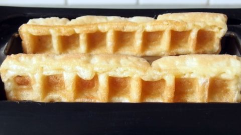Crispy Waffeln liegen frisch gebacken in einer schwarzen Form, bereit zum Servieren in einer modernen Küche.
