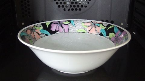 Eine Schüssel mit floraler Dekoration steht in einem Backofen und wartet darauf, zum sicheren Reinigen verwendet zu werden.