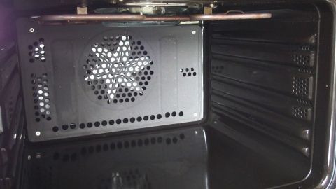 Ein Backofen mit einem schwarzen, perforierten Backblech im Inneren, bereit zum einfachen Reinigen ohne Kraftaufwand.