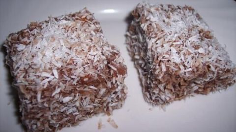 Zwei Lokum-Würfel mit Kokosraspeln sind auf einem weißen Teller angerichtet.