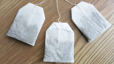 Kamillepäckchen liegen auf einem Holzuntergrund, bereit zur Anwendung gegen Ohrenschmerzen.
