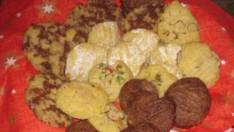 Eine Vielzahl von Plätzchen ist auf einem roten Tuch mit Sternen angeordnet, frisch aus der Mikrowelle zubereitet.