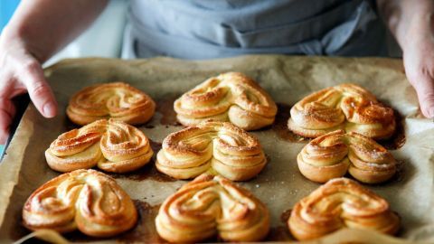 Goldene Hefegebäcke mit Muskatnuss werden frisch aus dem Ofen auf ein Backblech gelegt, bereit zum Servieren.