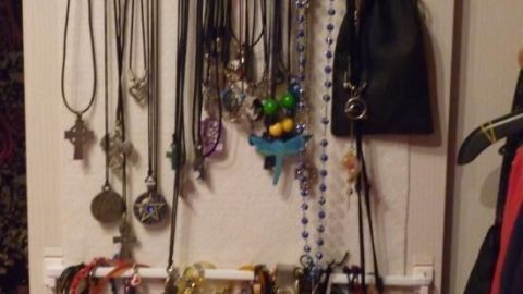 Ein Schmuckhalter zeigt viele Ketten und Armbänder, die ordentlich hängen, um sie im Kleiderschrank zu organisieren.