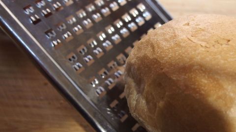 In diesem Artikel erfährst Du, wie Du altbackene Semmeln kreativ verwertest. Nutze die Reibe, um die Semmeln in feine Brösel zu verwandeln, perfekt für Panaden oder als Topping für Aufläufe und andere Gerichte. Ein Semmel wird auf einer Reibe gerieben, um altbackene Semmeln in eine weiche Konsistenz für das Rezept zu verwandeln.