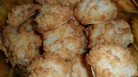 Kokosmakronen liegen gestapelt in einer Schale, frisch gebacken, goldbraun und knusprig, bereit zum Genießen.