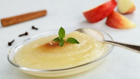 Dieser selbstgemachte Apfelbrei ist einfach zuzubereiten und schmeckt köstlich. Die frischen Äpfel und Gewürze machen ihn zu einem gesunden Genuss. Probiere das Rezept und bringe frischen Geschmack in deine Küche. Eine Schüssel mit selbstgemachtem Apfelbrei liegt auf einer Tischdecke. Neben ihr sind Apfelschnitze und Gewürze sichtbar.