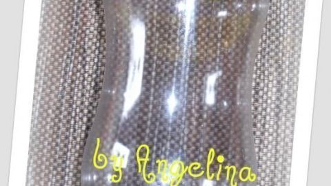 Ein transparenter Gewürzstreuer mit gelbem Deckel steht auf einem geflochtenen Untergrund. Text: "by Angelina".