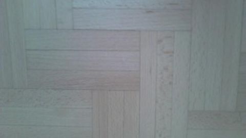 Ein Holzfußboden mit einem Fischgrätmuster. Die Oberfläche wirkt sanft und sauber, ideal für das Nebelfeucht Wischen.