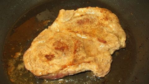 Zarte Schnitzel brutzeln in einer Pfanne mit goldbrauner Panade, umgeben von köstlichem Fett.