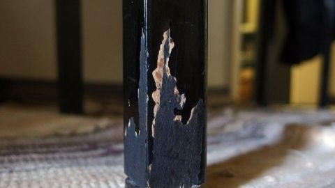 Ein beschädigtes Stuhlbein zeigt Kratzer und Abnutzungsspuren, verursacht durch das Knabbern von Haustieren im Wohnraum.