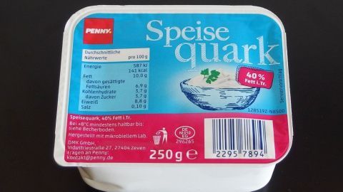 In einem weißen Behälter liegt Speisequark, während eine Nährwerttabelle die gesunden Inhaltsstoffe zeigt.
