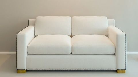 Ein weißes Microfasersofa steht vor einer hellen Wand, bereit für eine Reinigung, um sein frisches Aussehen zu bewahren.