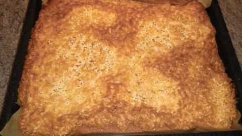 Ein Mandelkuchen vom Blech liegt goldbraun gebacken auf einem Blech, bereit zum Servieren und Genießen.