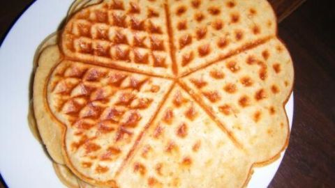 Goldbraune Waffeln liegen auf einem weißen Teller, perfekt geformt und warten darauf, serviert zu werden.