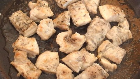 Stücke von gebratenem Fleisch liegen in einer Pfanne, bereit zum Geschnetzeltes, gebräunt und gewürzt.
