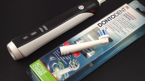 Günstigere Oral B Ersatzbürsten für die elektrische Zahnbürste. Eine elektrische Zahnbürste liegt neben einer Verpackung mit günstigeren Ersatzbürsten, bereit zur Anwendung.