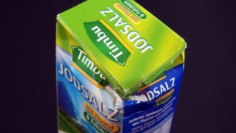 Eine geöffnete Verpackung von Jodsalz steht auf einem dunklen Hintergrund. Der Deckel ist beschädigt, was auf eine reduzierte Ware hinweist.