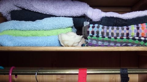 Weiche Handtücher liegen ordentlich übereinander auf einem Regal im Schrank, der nach frisch gewaschenem Duft riecht.