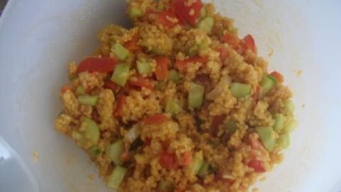 Bulgur-Salat in einer Schüssel zeigt bunte Zutaten wie Gurken und Paprika, vermischt für einen frischen, gesunden Genuss.