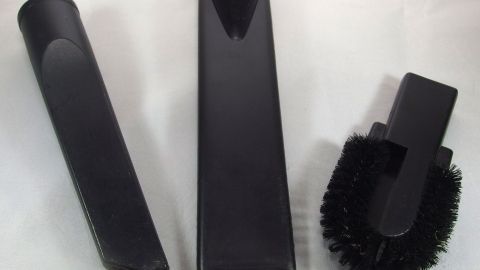 Drei schwarze Staubsauger-Aufsätze liegen auf einer weißen Oberfläche, bereit zur Verwendung für die Reinigung von verschiedenen Oberflächen.