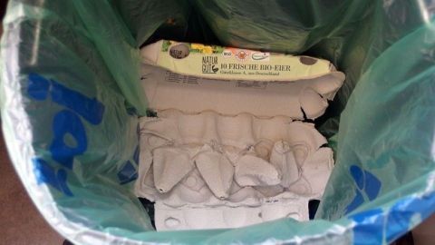 Um Abfalleimertüten tropffrei zu gestalten, kannst du Kartons von Eiern als Ablage im Beutel nutzen. Diese Technik hilft, die Tropfen aufzufangen und die Reinigung zu erleichtern. Weitere Tipps findest du im Artikel. Ein Abfalleimer ist mit einer türkisfarbenen Tüte gefüllt, in der Eierkartons ordentlich platziert sind, um Tropfen zu vermeiden.