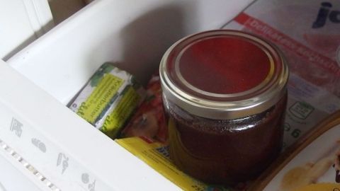 Ein Glas Marmelade steht in einem Gefrierfach, um die Haltbarkeit der Marmelade zu verlängern und frisch zu bleiben.