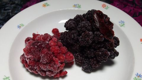 Ein Teller mit gefrorenen Waldbeeren, Himbeeren und Brombeeren, frisch angerichtet für den Monster-Waldbeeren-Shake.