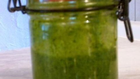 Ein Glas mit grünem Pesto steht auf einem Tisch, umgeben von einer hellen Umgebung. Text: "Cally hat’s gemacht!".