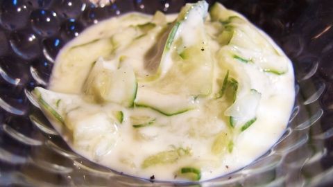 Gurkensalat liegt in einer Schüssel und ist mit einem cremigen Joghurt-Dill-Dressing überzogen, erfrischend und appetitlich.