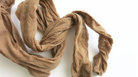 Ein brauner Strumpf liegt zerknittert auf einer weißen Oberfläche und eignet sich zum Putzen von Fenstern.