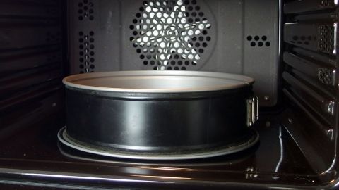 Ein Backofen zeigt eine Backform auf dem Rost, bereit zur Reinigung mit Backpulverpaste für bessere Hygiene.