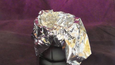 Selbstgemachte Muffinförmchen aus Alufolie stehen hier, um die traditionelle Backform in einer kreativen Küchenszene zu ersetzen.