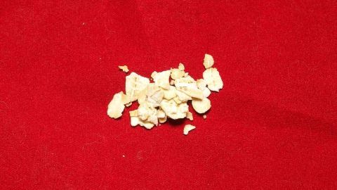 Ein Haufen aufgepopptes Popcorn liegt verstreut auf einem roten Tuch, während kleine Kinder im Hintergrund spielen.