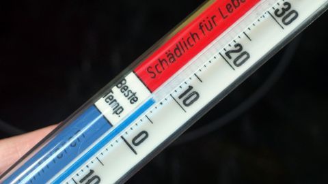 Ein Thermometer zeigt eine Temperaturmessung in einem kühlen Raum, um Geld zu sparen durch richtige Kühlung.