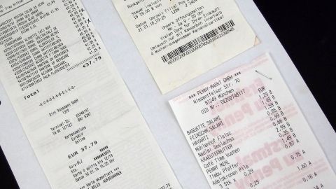 Mehrere Quittungen liegen auf einem schwarzen Hintergrund, um Sparpotentiale in den Finanzen sichtbar zu machen.