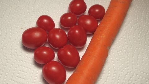 Frische Tomaten und eine Karotte liegen auf einem Küchenpapier, bereit für die Lagerung im Kühlschrank, um Gemüse länger haltbar zu machen.