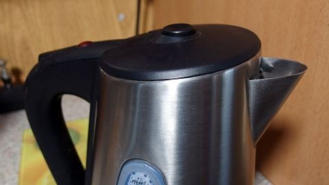 Ein Wasserkocher steht auf einer Oberfläche und wird zum Erhitzen von Wasser verwendet, um Energie beim Kochen zu sparen.