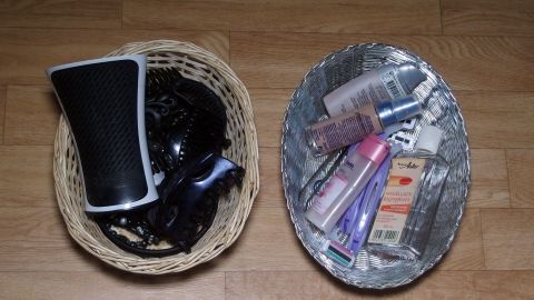 Körbchen auf dem Boden enthalten Kosmetikprodukte und persönliche Gegenstände, die zur Haushaltsorganisation dienen.
