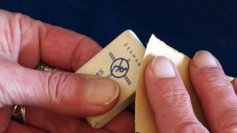 Zu glatte oder schmierig gewordene Radiergummis kann man mit Sandpapier auffrischen. Ein glatter Radiergummi wird mit Sandpapier bearbeitet, um seine Funktion im kreativen Arbeitsumfeld aufzufrischen.