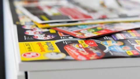Bunte Prospekte liegen ordentlich auf einem Tisch, um beim Großputz gegen Staub Unterstützung zu bieten.