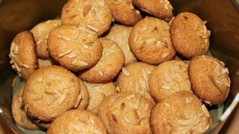 Kleine, runde Amaretti morbidi Kekse liegen übereinander in einer silbernen Schüssel und zeigen eine goldene, leicht gebräunte Oberfläche.