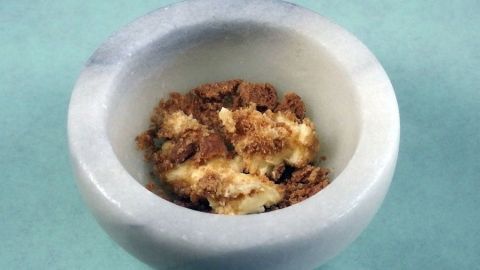 Eine Schale aus Marmor enthält eine cremige Mischung aus Butter und Spekulatius, bereit zum Verzehr.